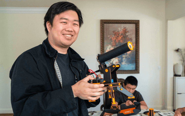 Jerry holding a student-built robotic arm