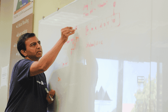 A guest speaker presenting at a whiteboard