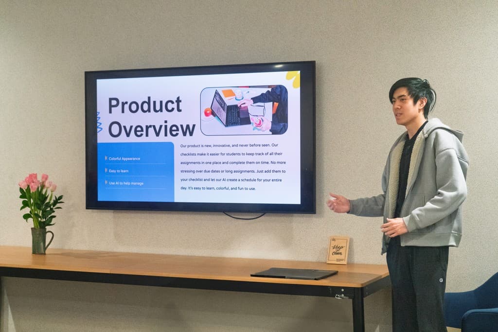 A student presenting a product overview on a large screen